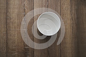 Top view of an empty white Bowl on a wooden background