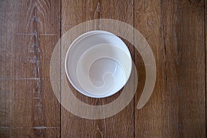 Top view of an empty white Bowl on a wooden background