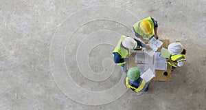 Top view of engineer, architect, contractor and foreman meeting at the construction building site with floor plan for real estate