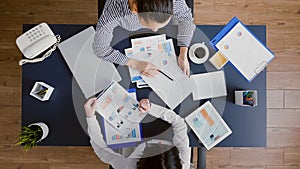Top view of entrepreneurs woman checking management graphs paperwork
