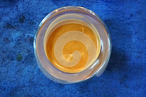 A top view of a espresso in a glass on a blue background, life style concept