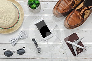 Top view / Flat lay accessoires to travel and technology with man / gentlemen clothing on white wooden table