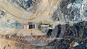 Top view of excavating machines moving along the quarry site. Building, construction process.