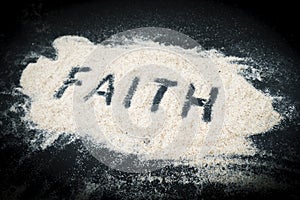 Top view of Faith text written on sand