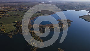 Top view of fall forest and lake. Autumn sunny evening over a forest lake