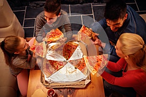 Top view of family eating pizza slices for the dinner