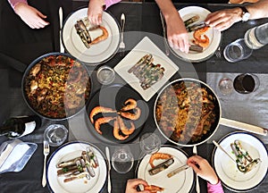 Top view of family eating Spanish Tapas around a white table from high view angle