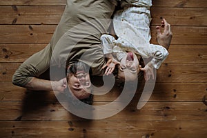 Top view of father with daughter lying on floor laughing together. Girls dad. Unconditional paternal love, Father& x27;s