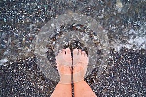 Top view of feet at the beach with sea waves. Grounding concept. connecting to nature photo