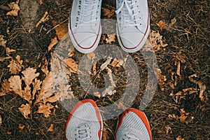 Top view feet of the male and female are couple lover standing on small autumn grass