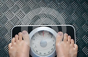 Top view of feet on weighing scale. Women weigh on a weight balance scale after diet control. Healthy body weight. Weight and fat