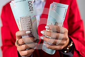 top view of female boss hands holding many cash dollars  on plain background.