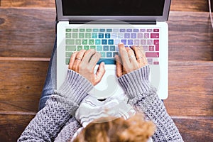 Top view of female caucasian hands working on coloured keyboard of laptop computer - concept of connected people and smart