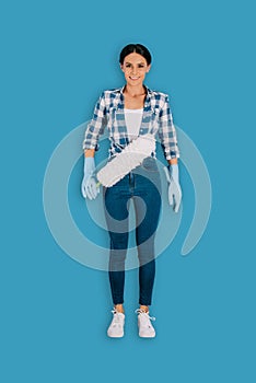 top view of female cleaner in protective gloves with duster