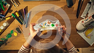 Top View of Female Designer Creating Hand Made Shoes, Drawing on Them at Home. Woman Working in