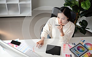 Top view of female designer working in graphic design using computer Sit and choose colors and work intently in your