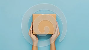 From a top view, a female hand holds a brown cardboard box against a light blue background, Ai Generated