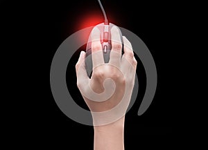 Top view of female hands clicking computer mouse isolated on black background with red spot on her finger. finger pain. Arthritis