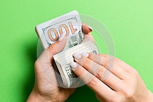 Top view of female hands counting money. One hundred and twenty dollar banknotes on colorful background. Salary concept. Bribe