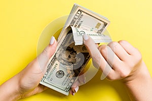 Top view of female hands counting money. Various dollar banknotes on colorful background. Salary concept. Bribe concept