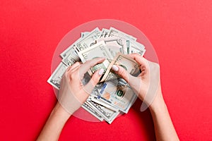 Top view of female hands counting money. Various dollar banknotes on colorful background. Salary concept. Bribe concept