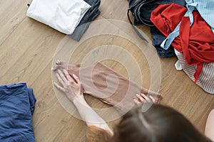 top view of female hands fold clothes. The process of sorting things.