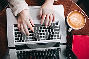 Top view female hands typing on laptop