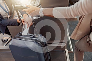 Female passenger weighing luggage at airport check in