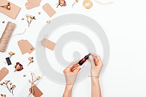 Top view female`s hands holds essential oil in little bottle