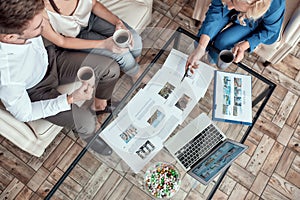 Top view of female travel agent working with clients in office and offering them tours