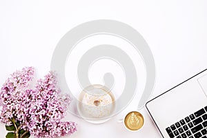 Top view of female worker desktop with laptop, flowers and different office supplies items. Feminine creative design workspace.