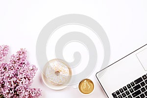 Top view of female worker desktop with laptop, flowers and different office supplies items. Feminine creative design workspace.