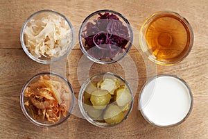 Top view of fermented foods - kimchi, white and purple sauerkraut, apple cider vinegar, gherkins and kefir