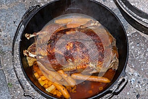 Top view of a filled roasted duck with crispy skin in the dutchoven pot.