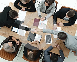 Top view. financial partners shaking hands at an office meeting .