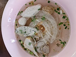 Top view, fish ball noodles with various vegetables, delicious soup in a plastic cup,