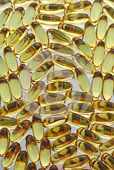 Top view of fish oil, omega 3 gel capsules scattered, lying randomly. Health care, vitamins and treatment concept