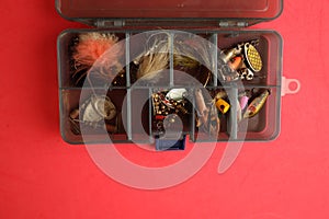 Top view of fishing lure kit on a red background