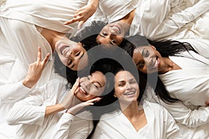 Diverse women lying in bed feels happy after spa procedures photo