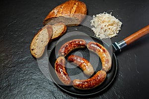 Top view five ruddy meat wieners fried in large frying pan