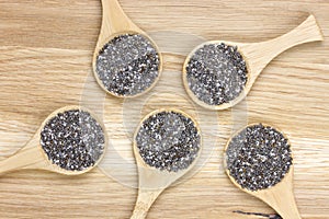 Top-view of five spoons filled with chia seeds