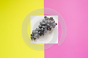 Top view of flat lay of bunch of grapes on double color sirface background f
