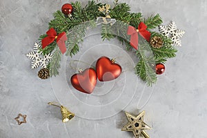 Top view flat lay christmas background with festive decorated pine tree branches with two heart shaped. toys. New year, love