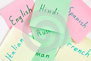 Top view flat lay of diferent languages which written on the reminder notepaper