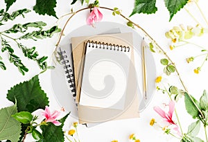 Top view flat lay empty note book with summer leaves and daisy flowers mockup