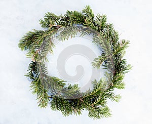 Top view flat lay green Christmas wreath on bright background. Traditional New year decoration concept. Space