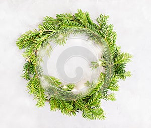 Top view flat lay green Christmas wreath with lights on bright background. Traditional New year decoration concept. Space