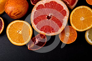 Top view, flat lay, macro. Sliced citrus fruits on a black background