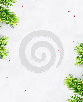 Top view flat lay natural Christmas tree branches corner frame on bright background. New year decor concept
