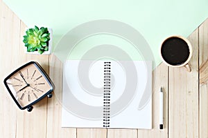 Top view or flat lay of open notebook paper with blank pages, accessories and coffee cup on wooden background, ready for adding or